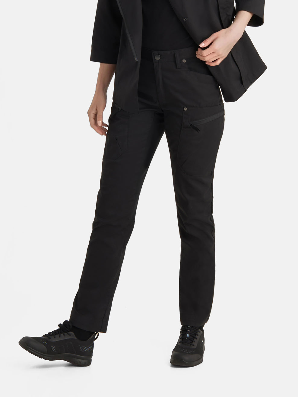 Kuvassa naismallilla Image Wearin mustat joustavat reisitaskuhousut sekä Sievin Fly fresh-lenkkarit.