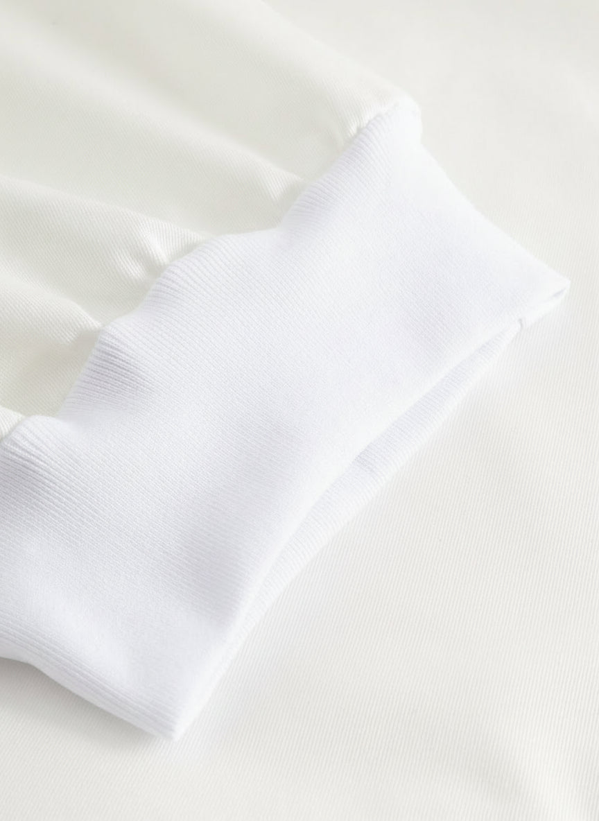 Yksityiskohtakuva valkoisten työhousujen lahkeensuun resorista.