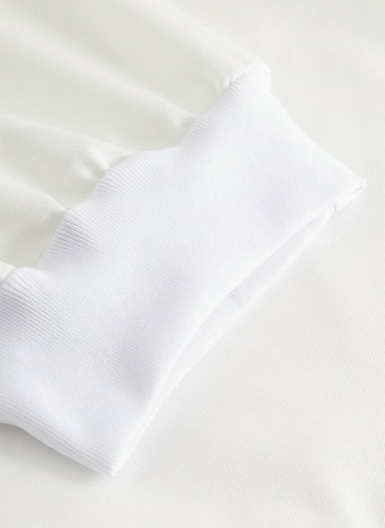 Yksityiskohtakuva valkoisten työhousujen lahkeensuun resorista.