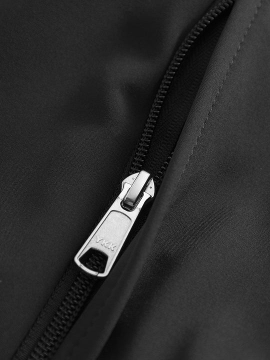 Yksityiskohtakuva mustan Softshell-takin taskun vetoketjusta.