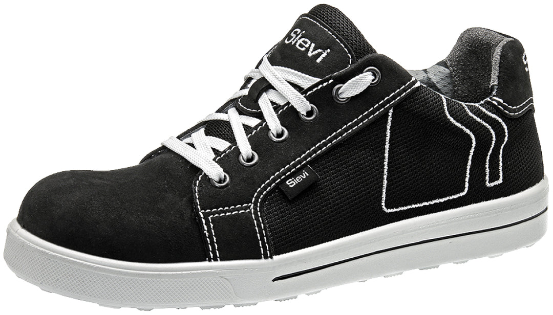 Sievin mustavalkoinen sporttisen näköinen matala turvakenkä. Valkoinen pohja, nauhat ja koristetikkaukset antavat ilmettä muuten mustaan kenkään. Edessä nauhakiinnitys.