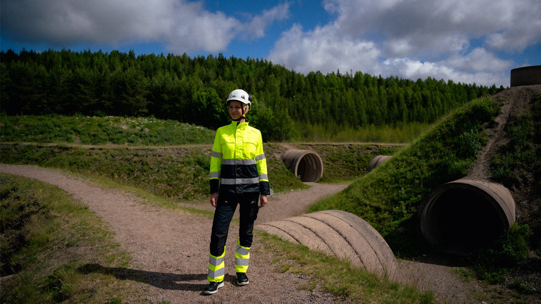 Image Wearin varoitusvaatteissa nainen metsämaisemassa