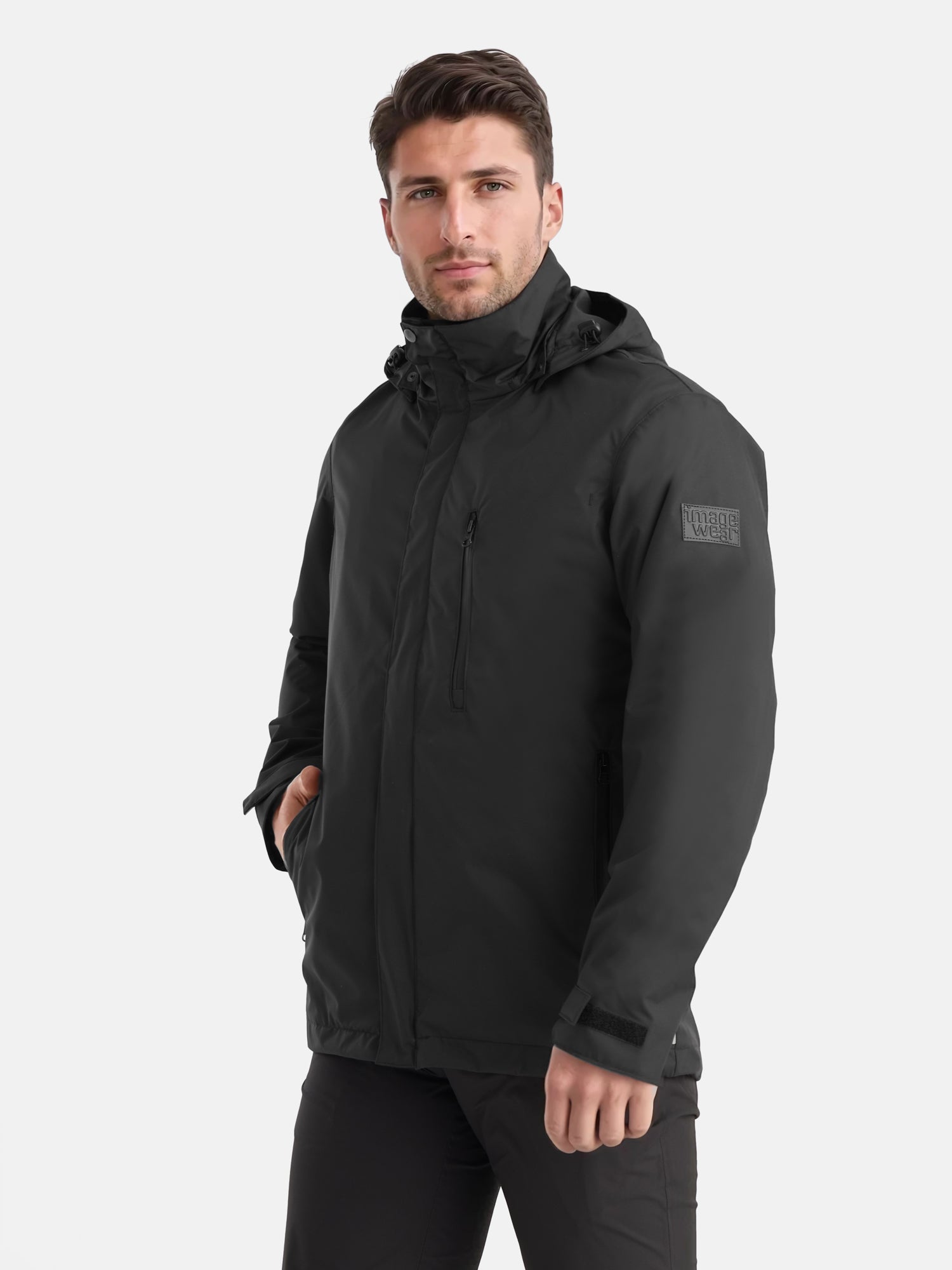 Kuvassa  miehellä musta vedenkestävä, hupullinen parkatakki. 