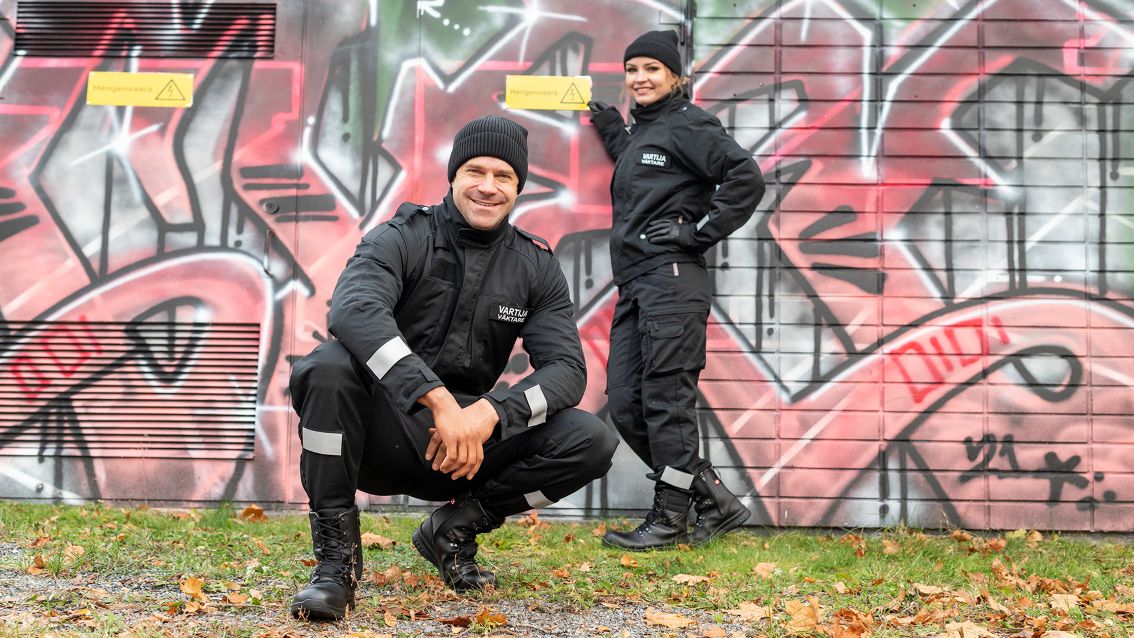 Kuvassa mies ja nainen ovat ulkona Image Wearin vartijan työvaatteissa. 