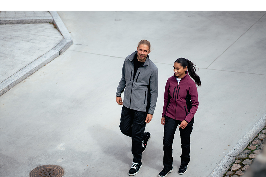 Miehellä ja naisella on kuvassa päällä Image Wearin Softshell-takit Vire mallistosta, mustat joustohousut sekä trikoopaidat. 