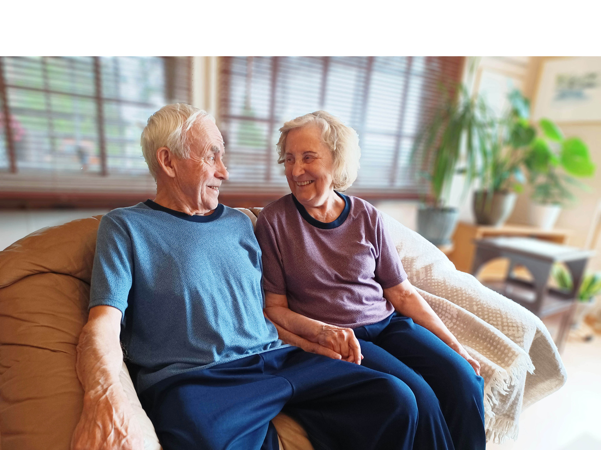 Kuvassa nainen hoitaa viherkasvia Image Wearin  kanerva-tummansinisessä oloasussa. 