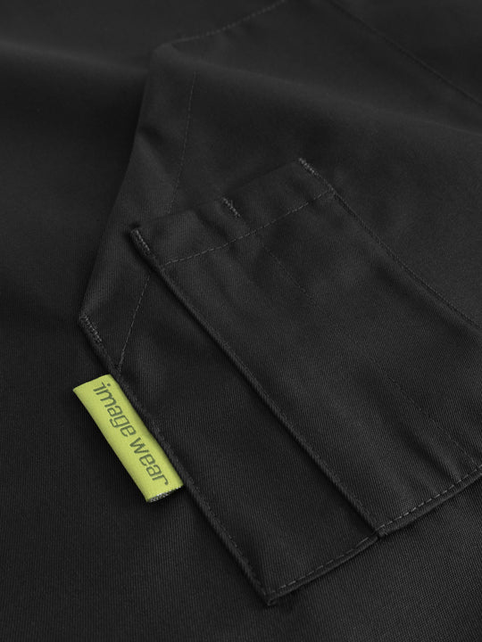 Yksityiskohtakuva mustan pitkän esiliinan taskusta ja kynätaskusta. 