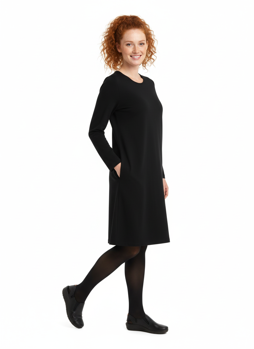 Kuvassa naismallilla päällä Image Wearin musta pitkähihainen ja taskullinen neulosmekko. Jalassa mallilla on Image Wearin Rumba-nimiset työkengät.