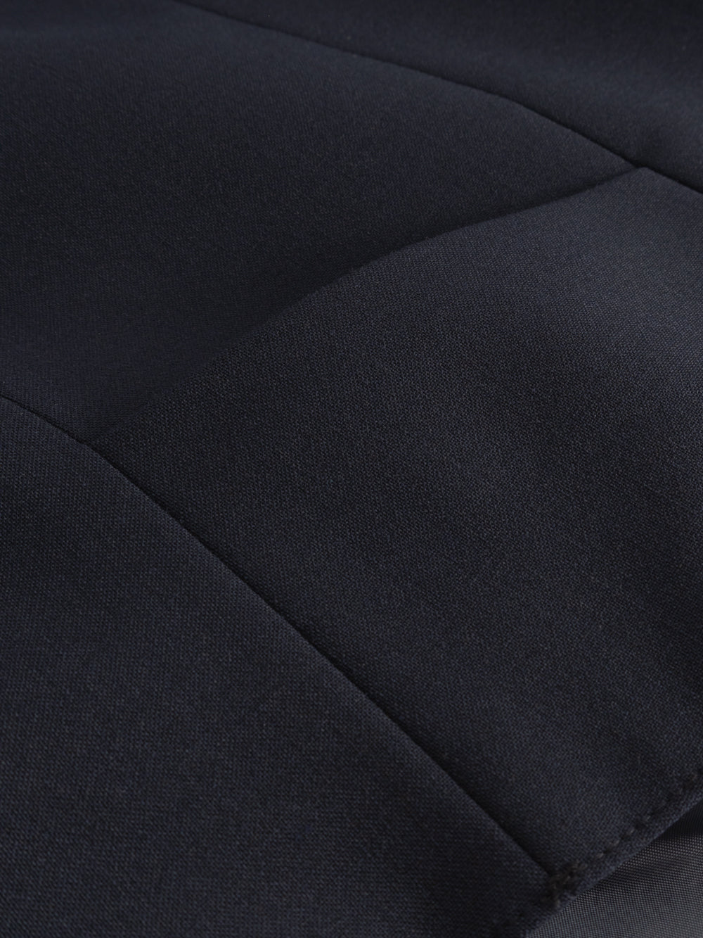 Yksityiskohtakuva tummansinisen liivin sivussa olevasta taskusta. 