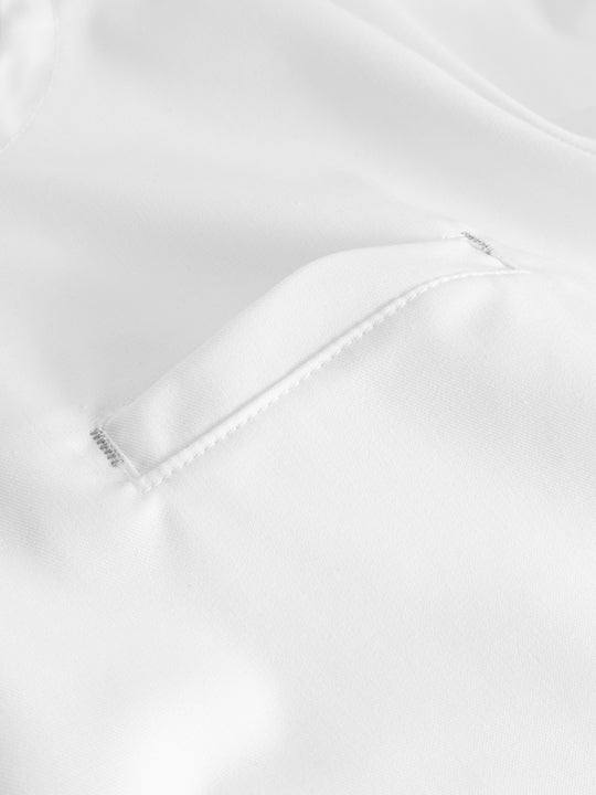 Yksityiskohtakuva valkoisen naisten toimipaikka/ hoitajan työpaidan rintataskusta.