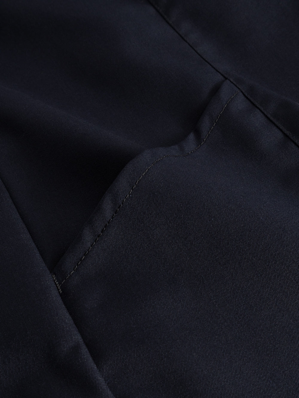 Yksityiskohtakuva tummansinisen neppariliivin taskun suusta. 