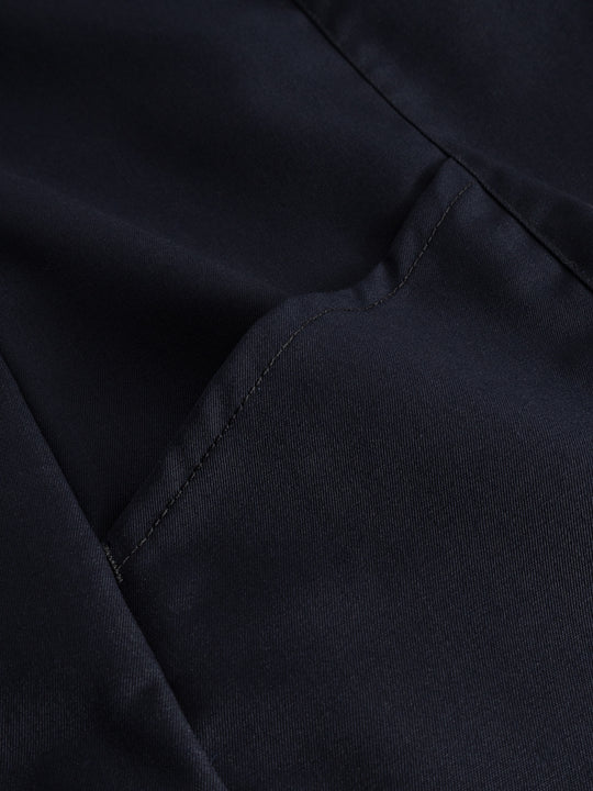 Yksityiskohtakuva tummansinisen neppariliivin taskun suusta. 