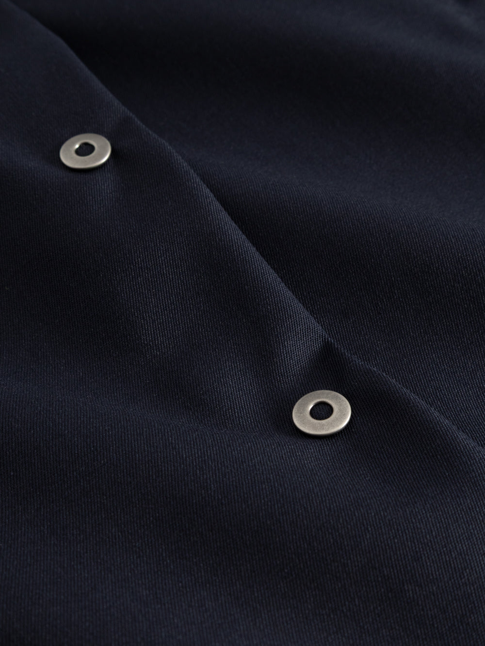 Yksityiskohtakuva tummansinisen neppariliivin neppareista. 