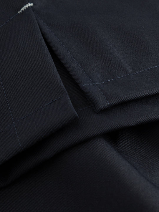 Yksityiskohtakuva tummansinisen työliivin sivuhalkiosta. 