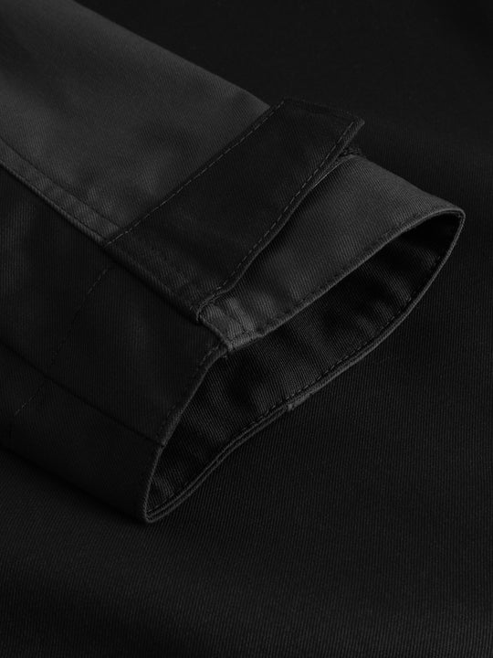 Yksityiskohtakuva mustan Flexy-takin hihansuun tamppikiristyksestä.