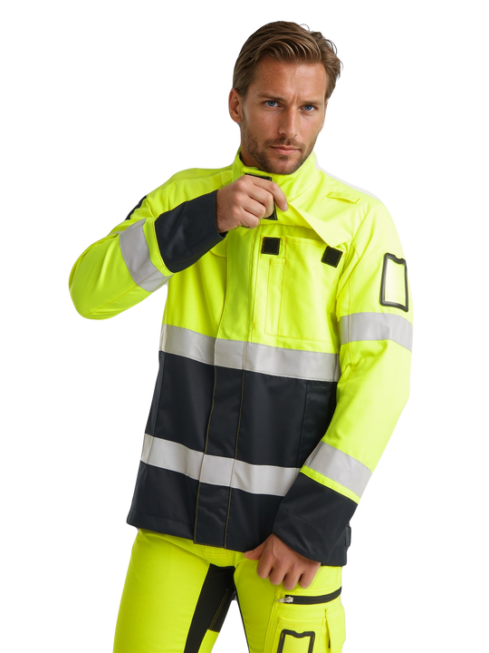 Kuvassa miesmallilla päällä keltainen varoitustakki ja -joustohousut. Takissa heijastimet, taskuja sekä hihassa käyntikorttikotelo. 