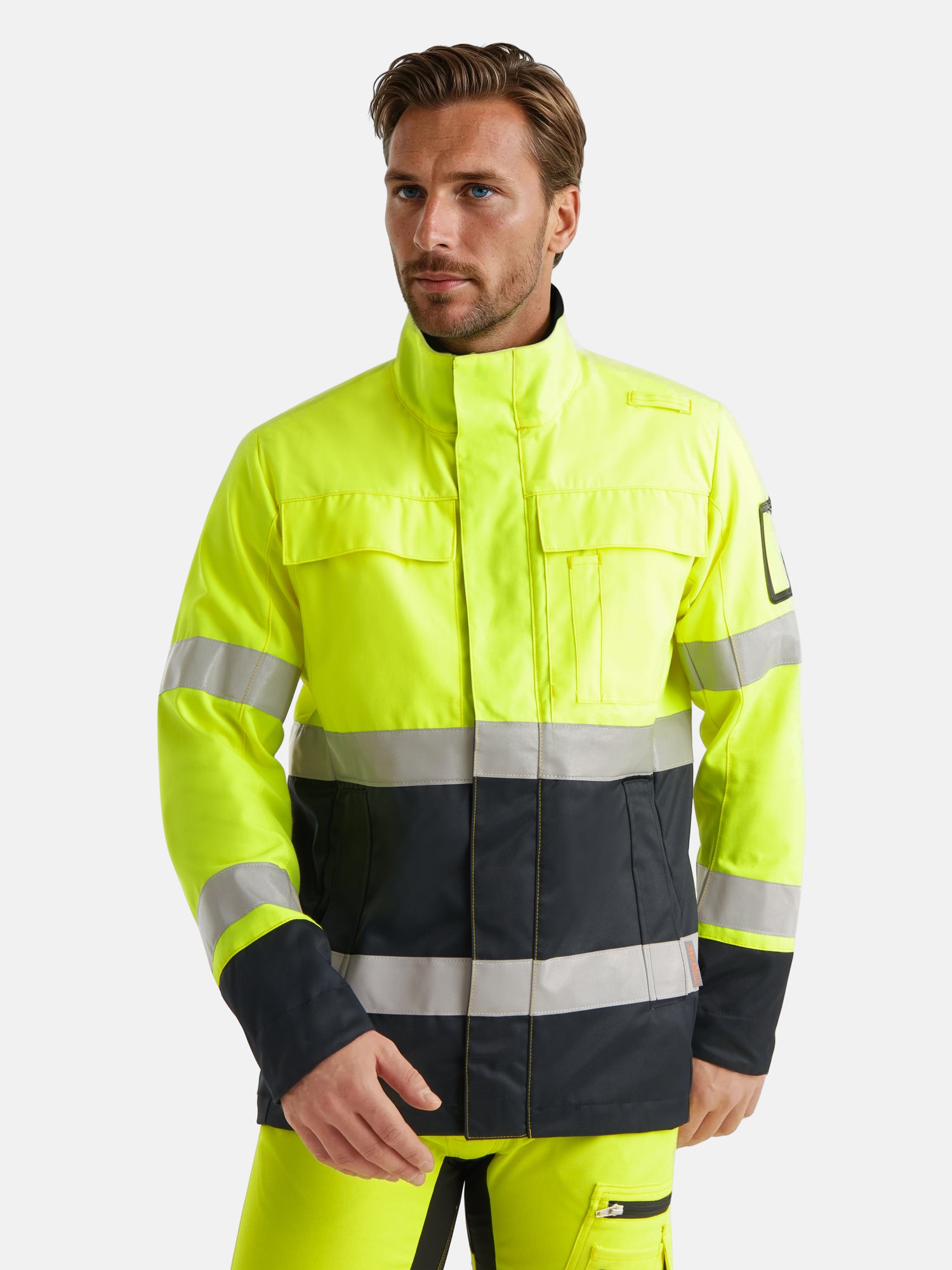 Kuvassa miesmallilla Image Wearin kelta-musta varoitustakki ja keltaiset varoitushousut. 