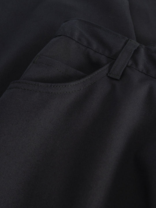 Yksityiskohtakuva tummansinisten naisten työhousujen taskusta. 