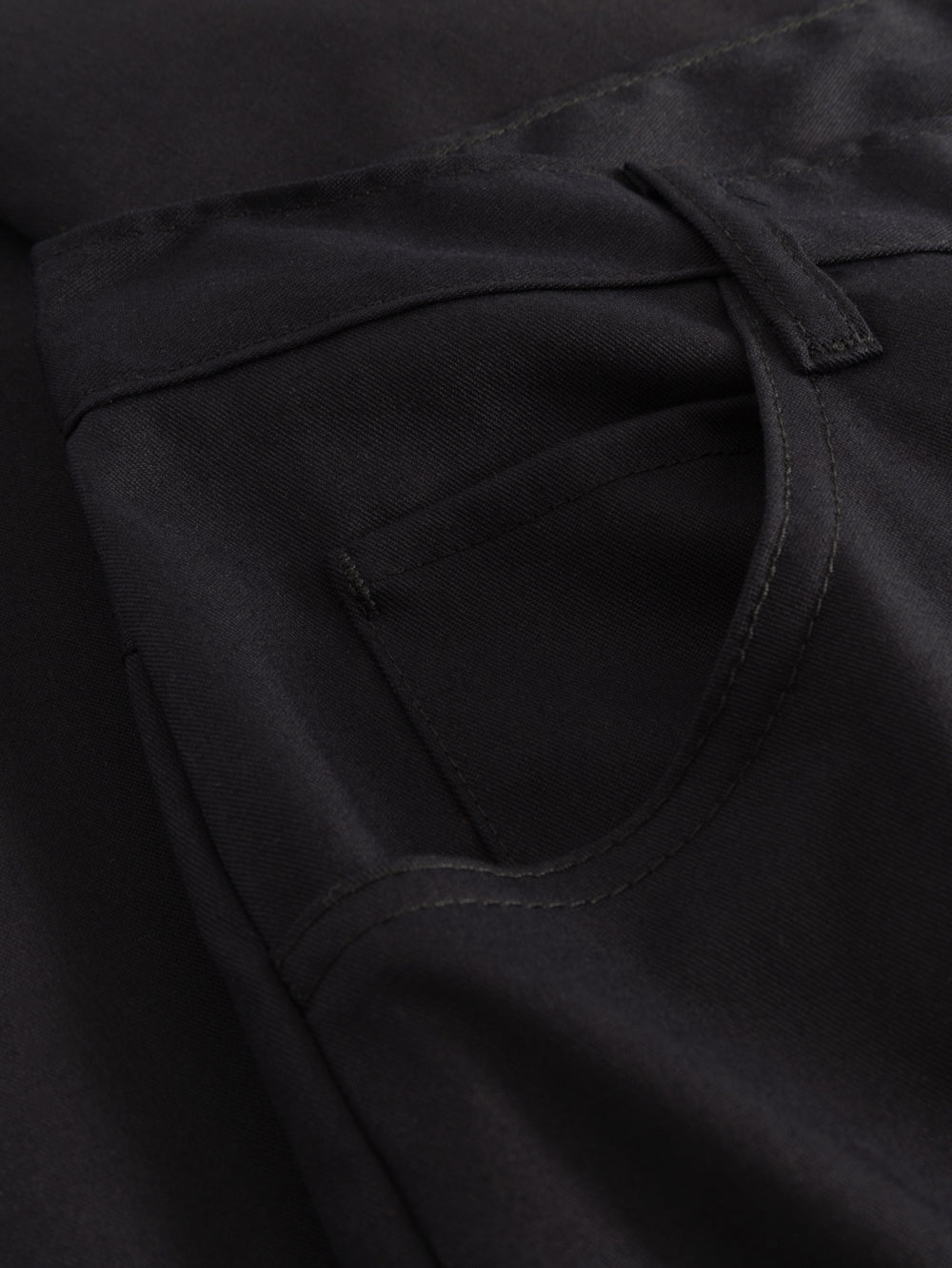 Yksityiskohtakuva tummansinisten farkkumallisten työhousujen sivutaskusta. 