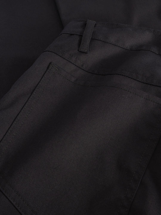 Yksityiskohtakuva tummansinisten farkkumallisten työhousujen takataskusta.