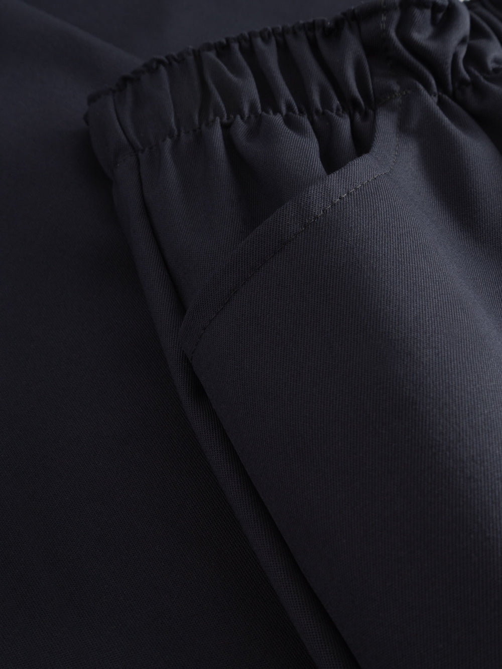 Yksityiskohtakuva tummansinisten työhousujen sivutaskusta. 