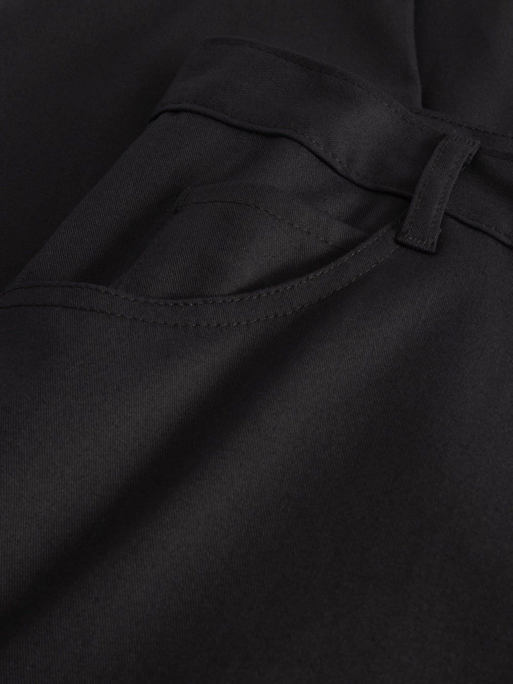 Yksityiskohtakuva miesten tummansinisten reisitaskuhousujen sivutaskusta. 