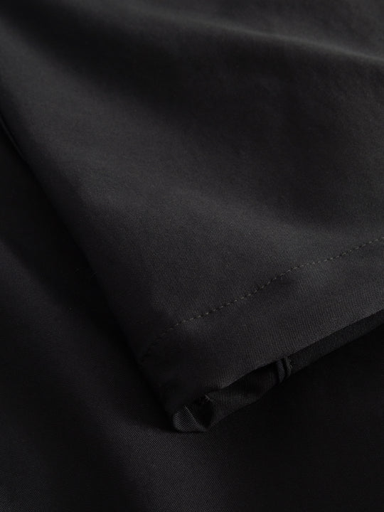 Yksityiskohtakuva tummansinisten housujen lahkeesta. 