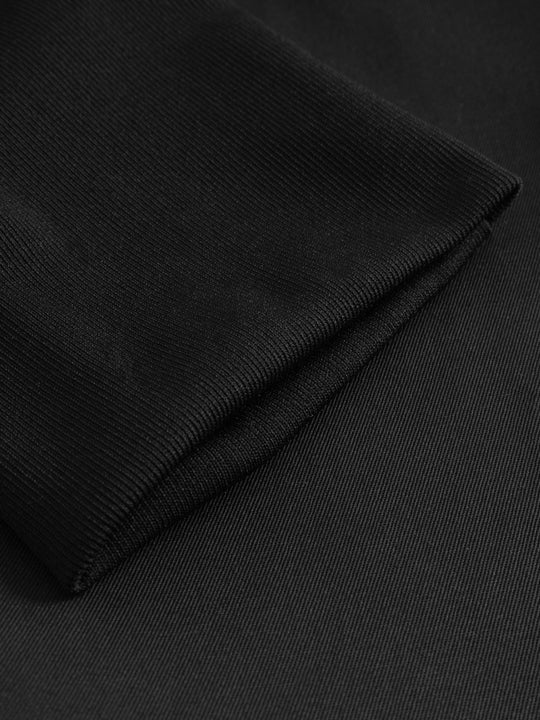 Yksityiskohtakuva mustien kuminauhavyötäröisten housujen lahkeen suun resorista. 