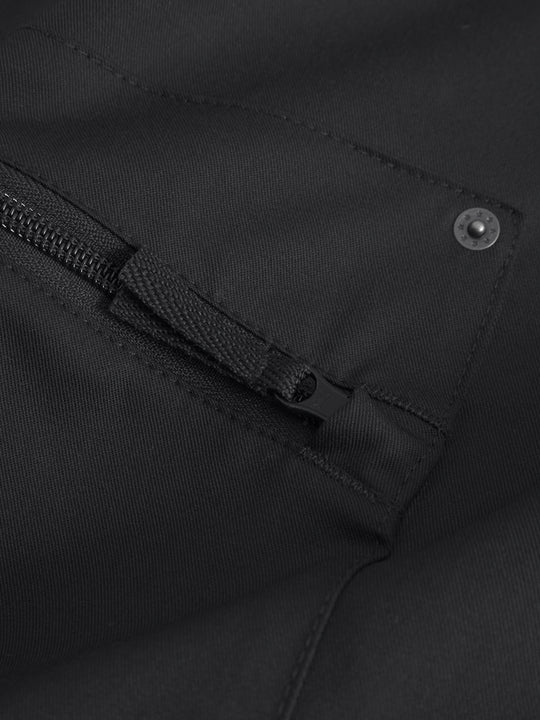 Yksityiskohtakuva mustien reisitaskuhousujen vetoketjullisesta reisitaskusta. 