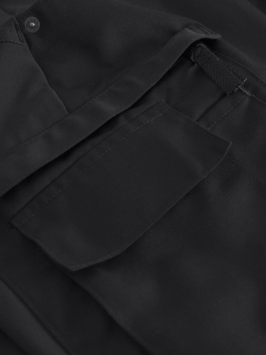 Yksityiskohtakuva mustien reisitaskuhousujen reisitaskuista. 