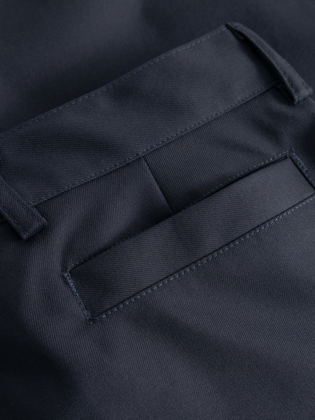 Yksityiskohtakuva tummansinisten housujen takataskusta. 