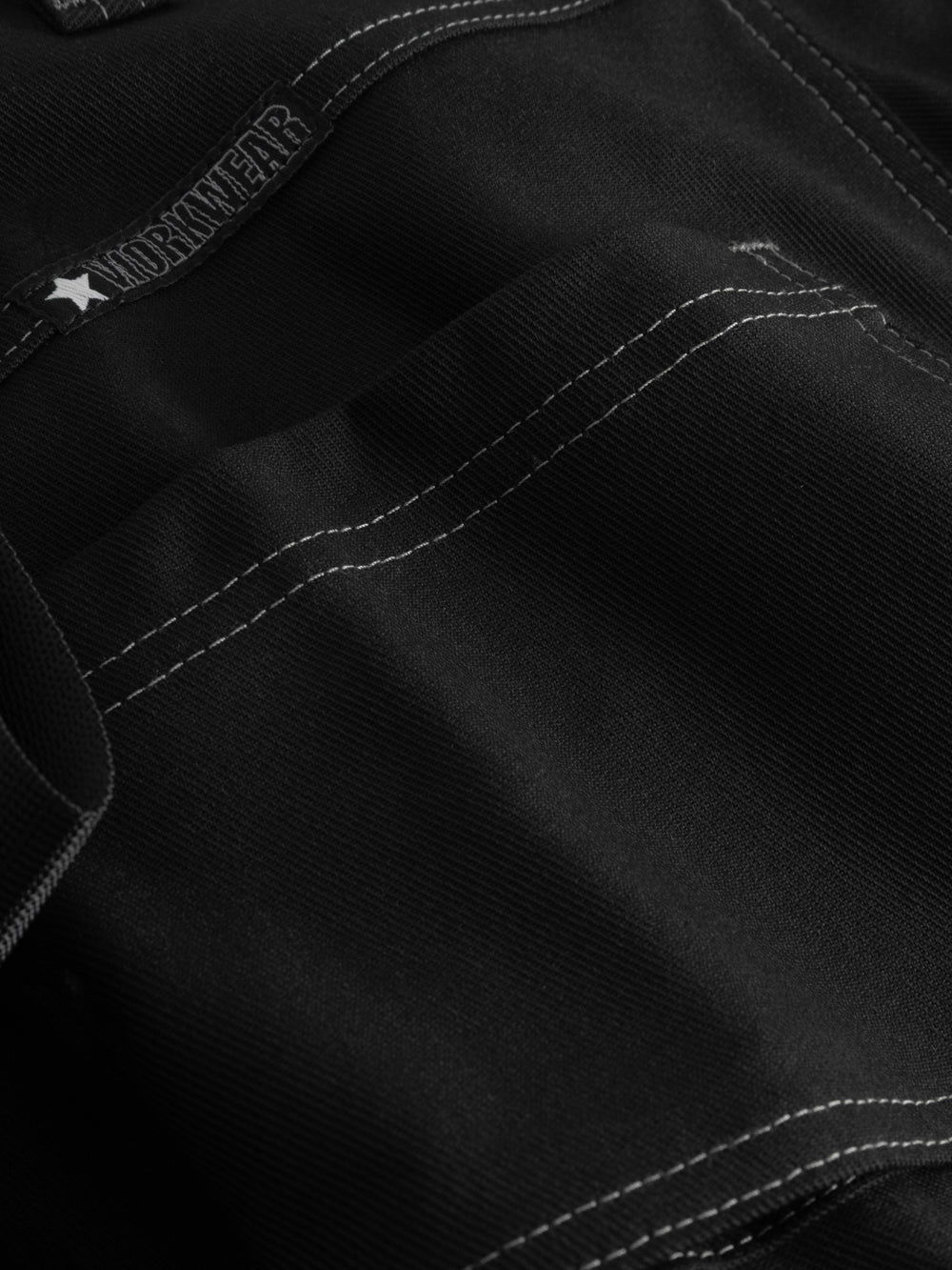 Yksityiskohtakuva mustien työhousujen takataskusta. 