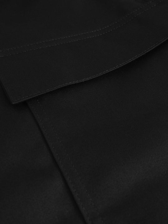 Yksityiskohtakuva mustien palosuojattujen työhousujen taskusta.