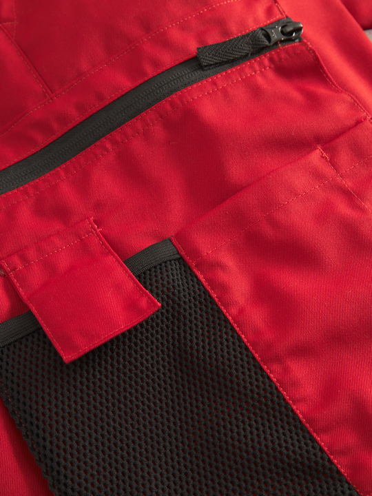 Yksityiskohta punaisten Lanssi-malliston työhousujen vetoketjutaskusta. 