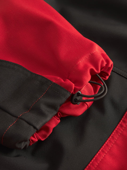 Yksityiskohtakuva punaisten Lanssi-housujen lahkeensuun kiristysnauhasta. 