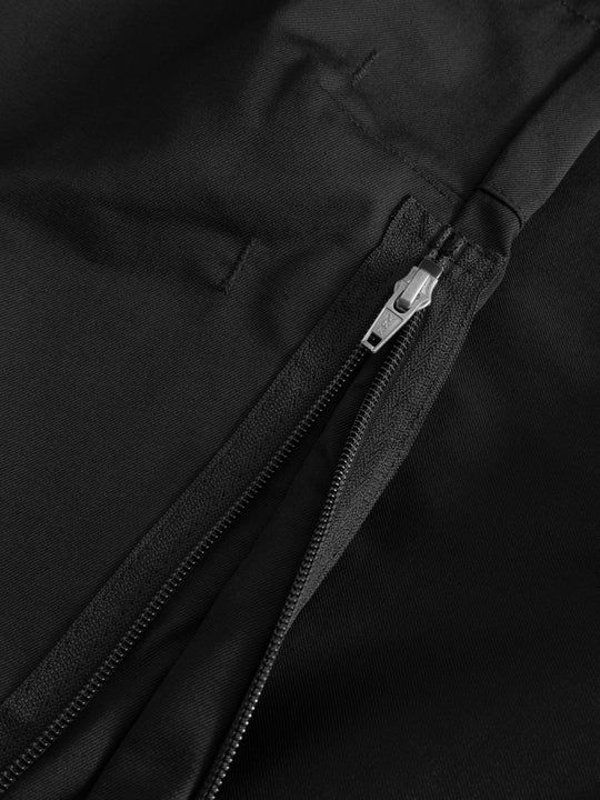 Yksityiskohtakuva mustan vartijahaalarin vetoketjusta. 