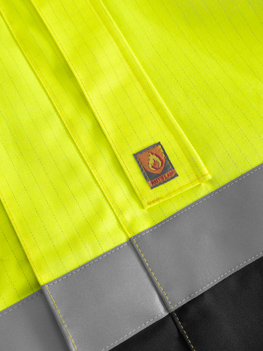 Yksityiskohtakuva palosuojatun takin taskusta ja antiflame-merkistä. 