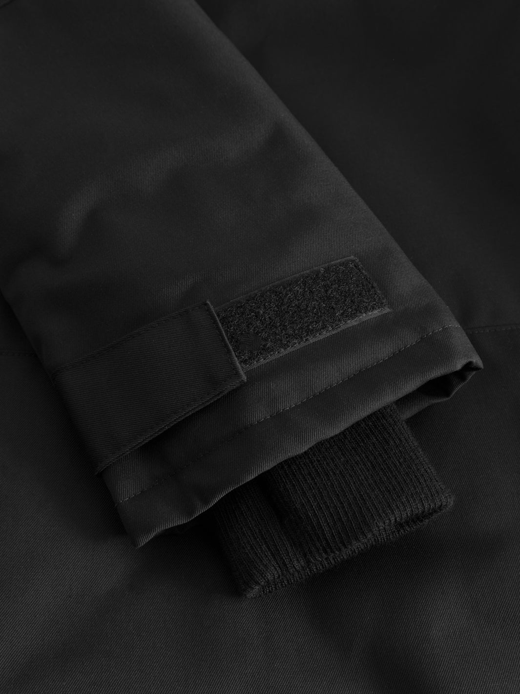 Yksityiskohtakuva mustan Pyry talvitakin hihansuun tarrakiristystampista. 