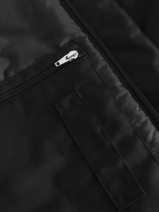 Yksityiskohtakuva mustan naisten Pyry talvitakin vetoketjullisesta povitaskusta ja kynätaskusta.