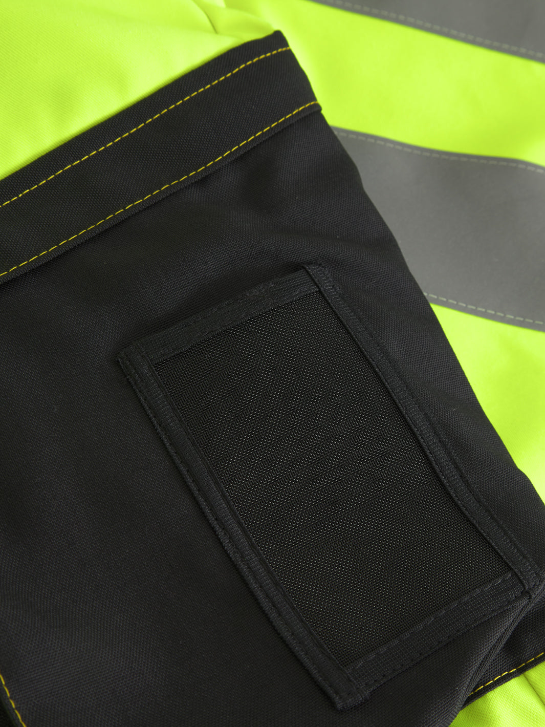 Yksityiskohtakuva näkyvien keltaisten talvihousujen ID-korttikotelosta. 