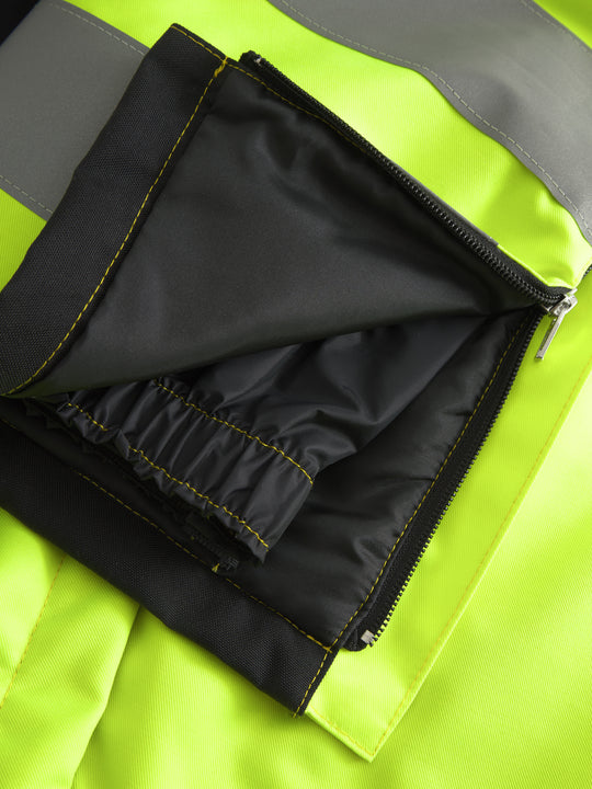 Yksityiskohtakuva näkyvien keltaisten talvihousujen lahkeiden vetoketjusta ja sisäpussista. 