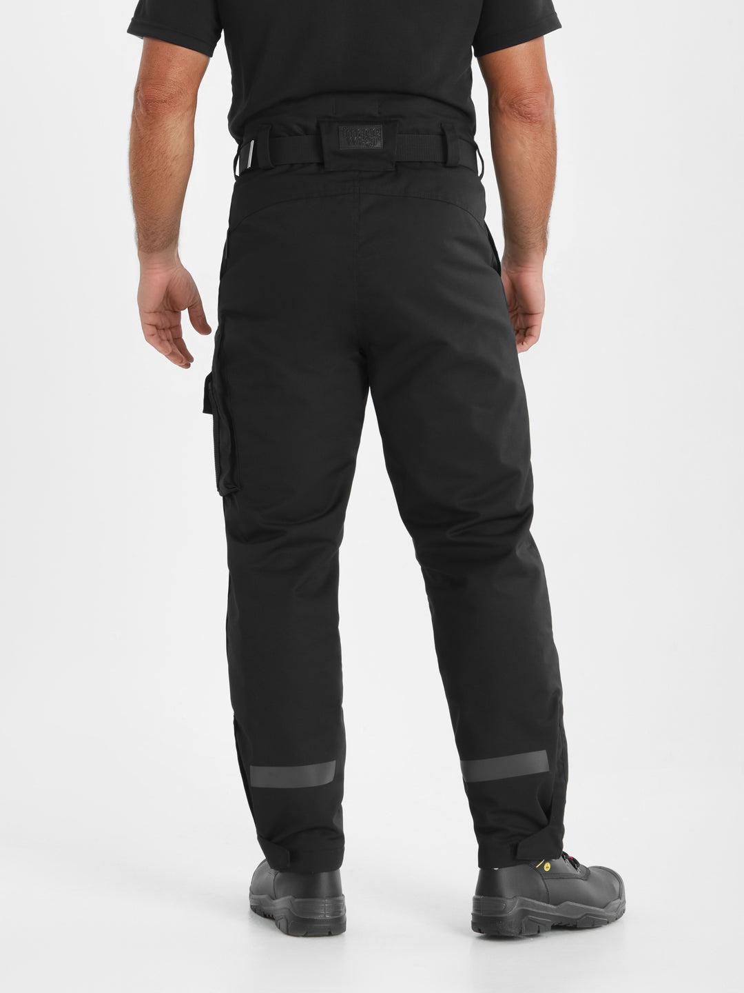 Mustat Pyry talvihousut takaapäin kuvattuna miesmallin päällä. Takana lahkeessa sävysävyyn heijastinnauhat. 