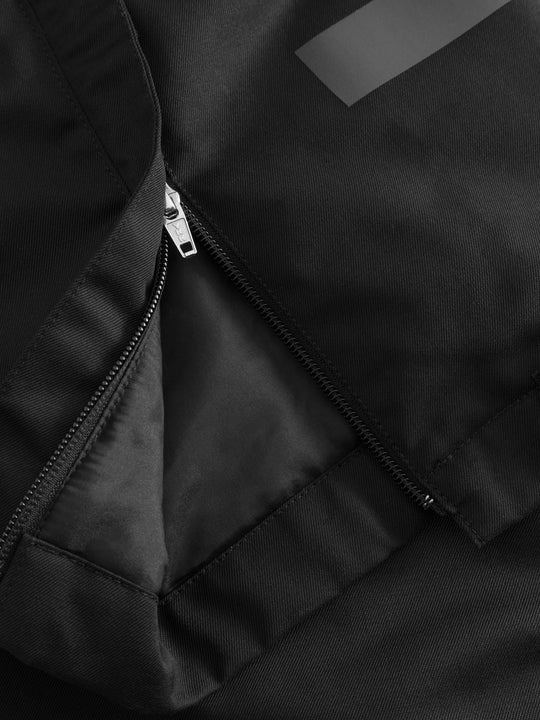 Yksityiskohtakuva mustien Pyry talvihousujen lahkeensuun vetoketjusta. 