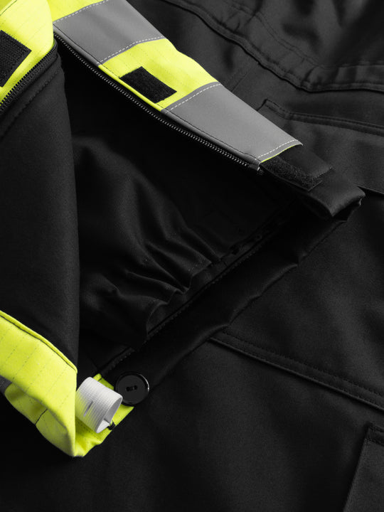 Yksityiskohtakuva palosuojatun liivihaalarin lahkeensuun vetoketjusta ja kiristysnauhasta. 