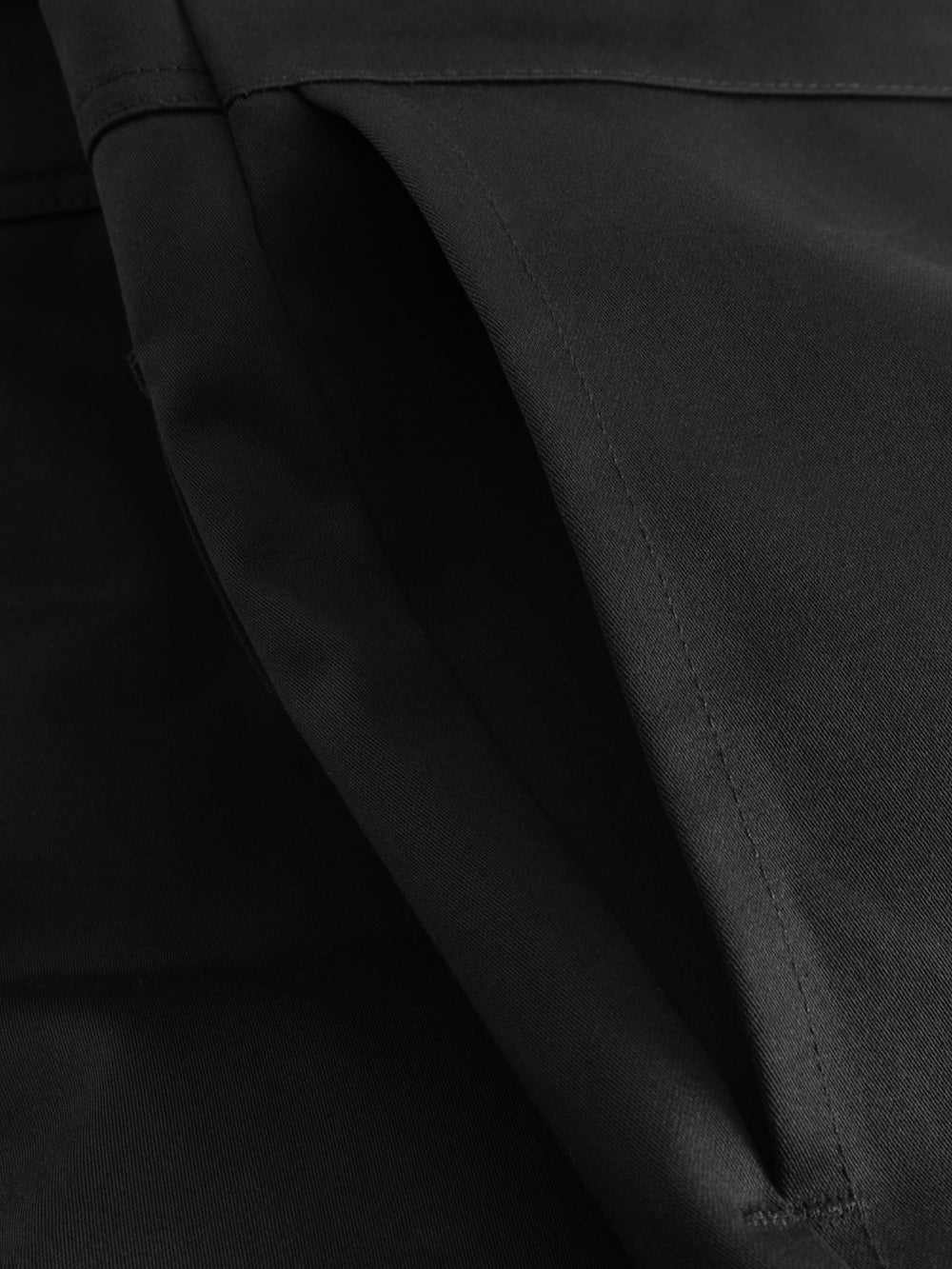 Yksityiskohtakuva palosuojatun liivihaalarin sivutaskusta. 