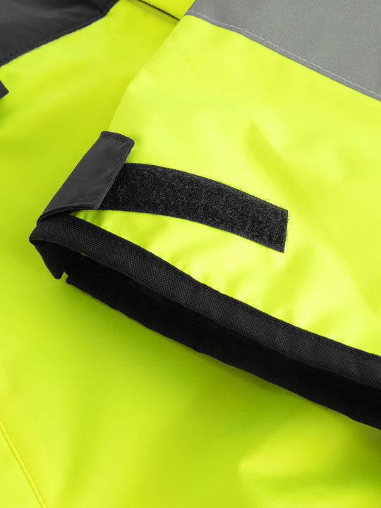 Yksityiskohtakuva keltaisen varoitustakin hihan suun tarrakiristysnauhasta. 