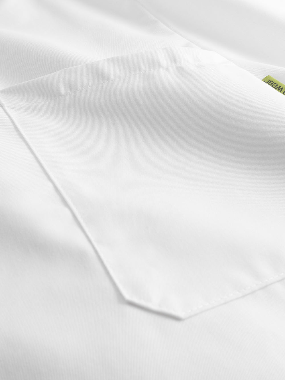 Yksityiskohtakuva valkoisen työtakin taskusta. 