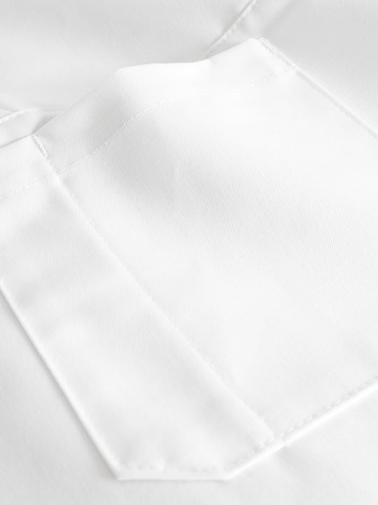 Yksityiskohtakuva valkoisen lyhythihaisen toimipaikkapuseron taskusta ja kynätaskusta.