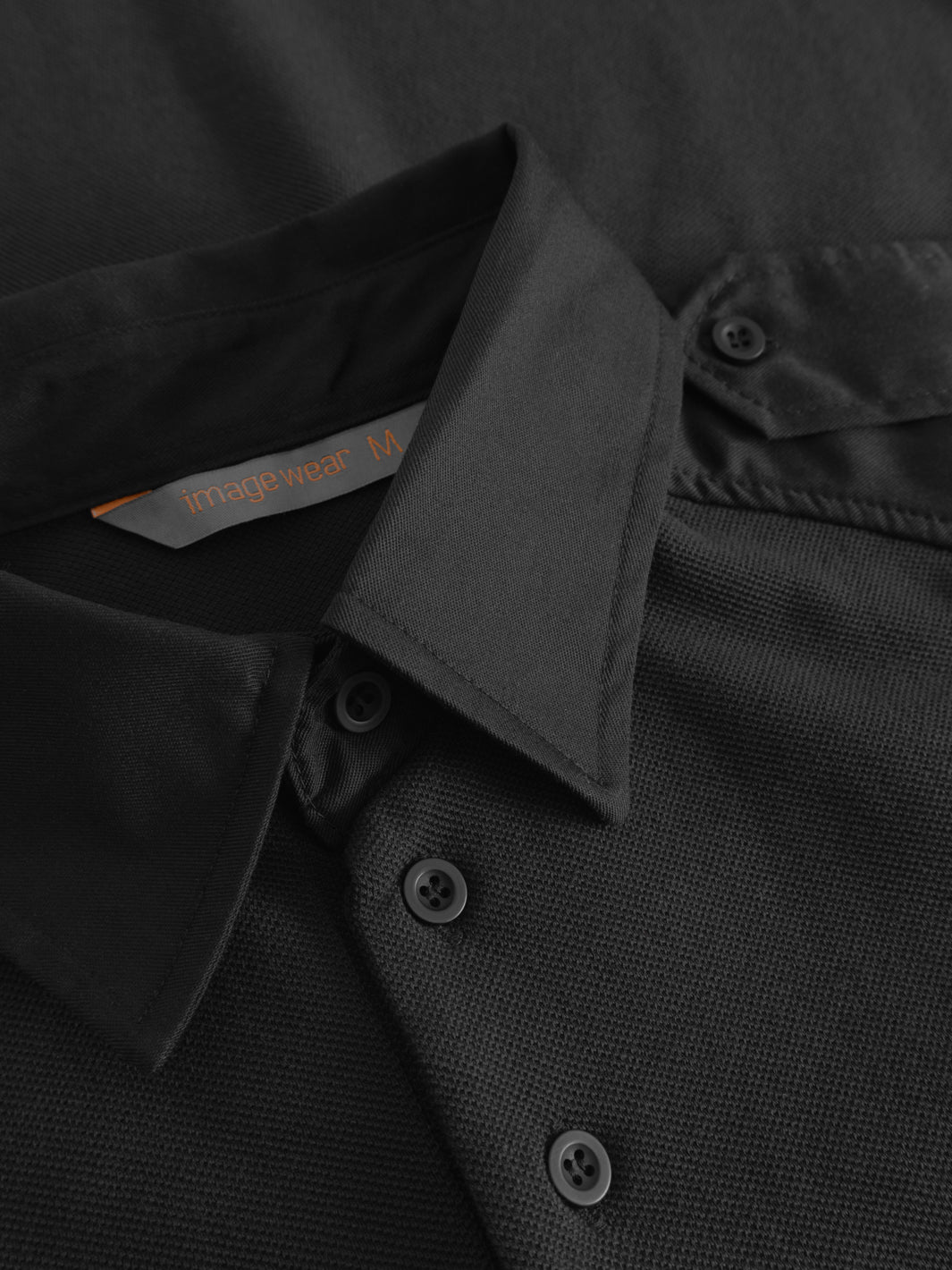 Yksityiskohtakuva mustan vartijan pikeepaidan kauluksesta ja etunapituksesta. 