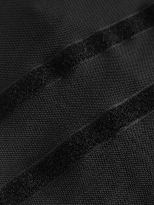 Yksityiskohtakuva mustan vartijan pikeepaidan tarrapaikoista selässä. 